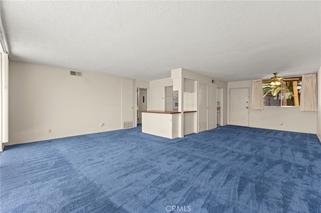 unfurnished living room with carpet flooring, a textured ceiling, a ceiling fan, and visible vents