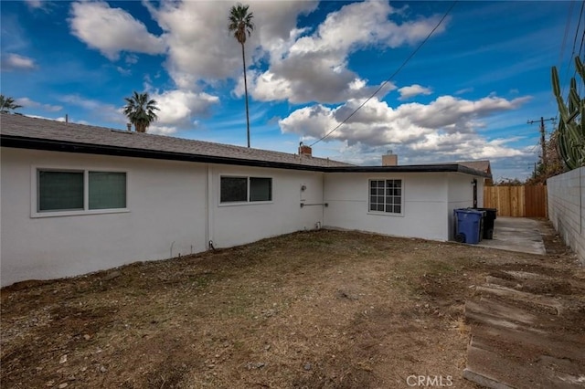 back of property with a fenced backyard and stucco siding