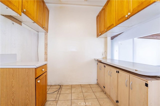 kitchen featuring light tile patterned floors, light countertops, and a peninsula