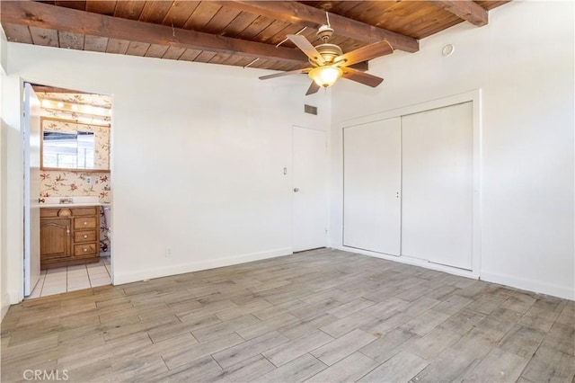 unfurnished bedroom featuring a closet, visible vents, light wood-style flooring, wood ceiling, and beamed ceiling