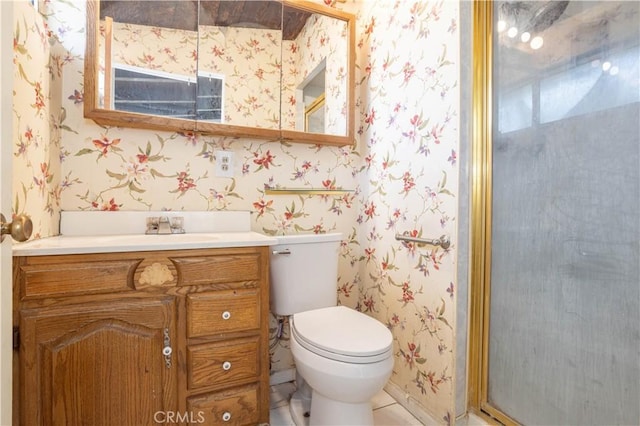 bathroom with toilet, wallpapered walls, and vanity