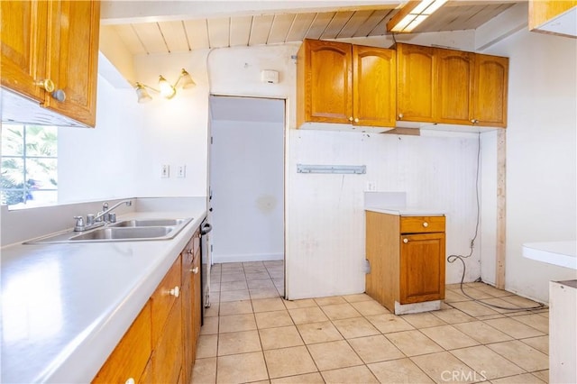 kitchen with light tile patterned floors, brown cabinetry, and light countertops