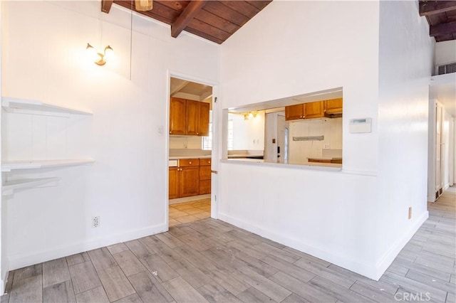 kitchen with light wood-style floors, beamed ceiling, wood ceiling, and brown cabinets