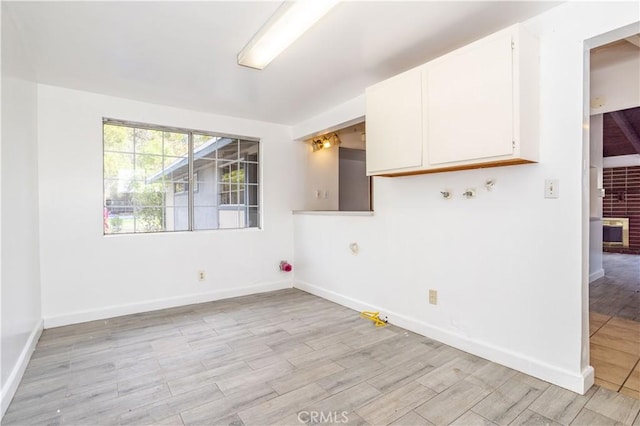 empty room featuring light wood-style flooring and baseboards