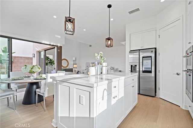 kitchen with visible vents, light countertops, light wood-style flooring, appliances with stainless steel finishes, and white cabinetry