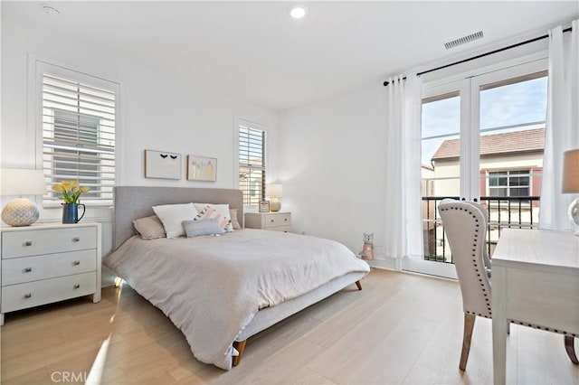 bedroom featuring visible vents, light wood-style flooring, and french doors