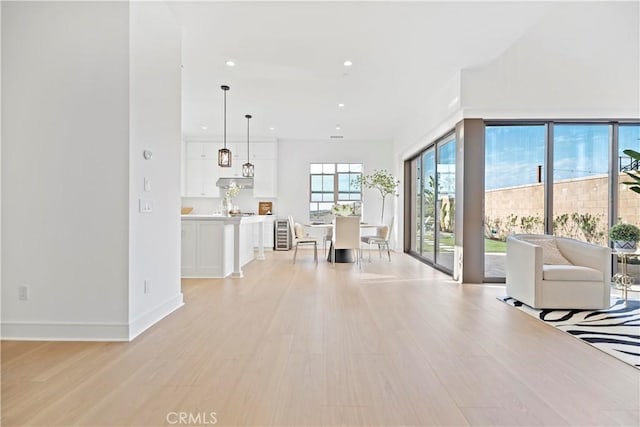 unfurnished living room featuring recessed lighting, baseboards, and light wood-style flooring