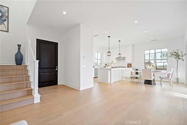 foyer with stairway, recessed lighting, light wood-style flooring, and baseboards