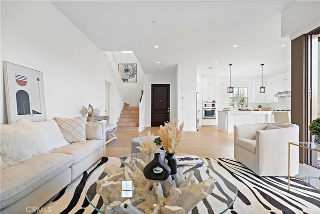 living room with recessed lighting, stairs, and light wood-style floors