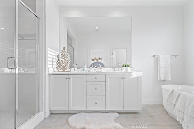 full bath featuring tile patterned floors, a sink, a shower stall, double vanity, and a soaking tub