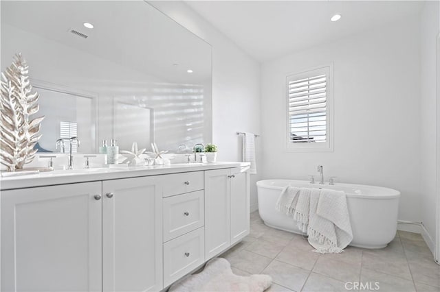 full bathroom featuring tile patterned flooring, visible vents, double vanity, recessed lighting, and a soaking tub