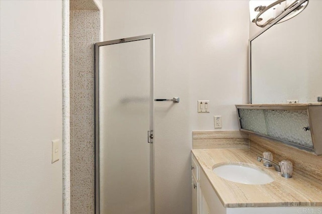 full bath with a stall shower and vanity