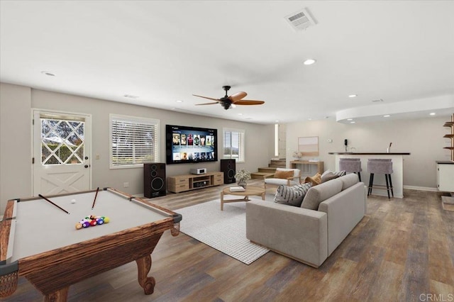 living area featuring recessed lighting, visible vents, wood finished floors, bar area, and baseboards