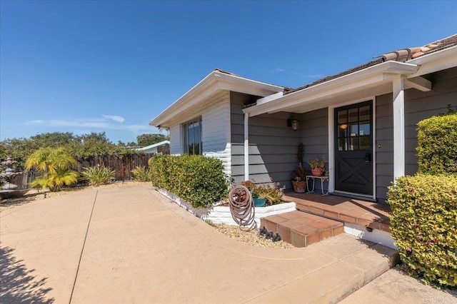 entrance to property featuring fence