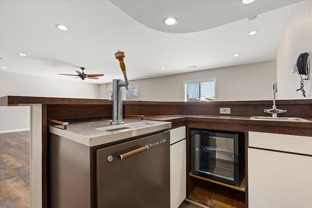 kitchen with beverage cooler, wood finished floors, a sink, and recessed lighting