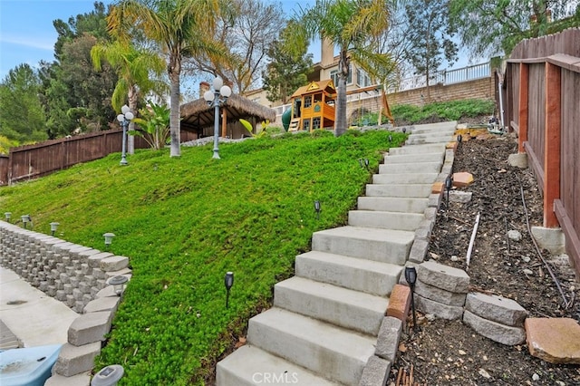 view of yard with a fenced backyard and stairs