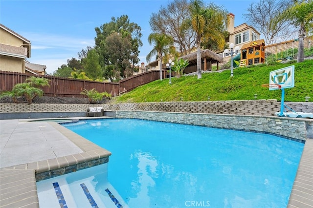 view of swimming pool featuring a patio, fence, a fenced in pool, and a yard