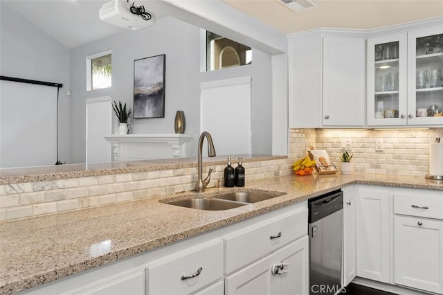 kitchen with a sink, white cabinetry, backsplash, light stone countertops, and dishwasher