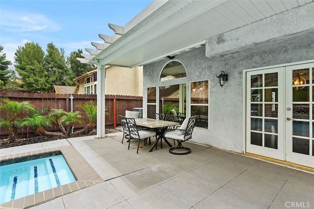 view of patio with french doors, outdoor dining area, fence, and a fenced in pool