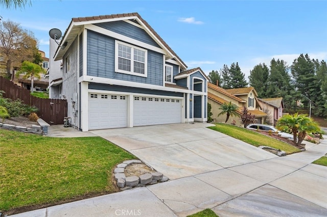 view of front of house with a front lawn, fence, driveway, and an attached garage