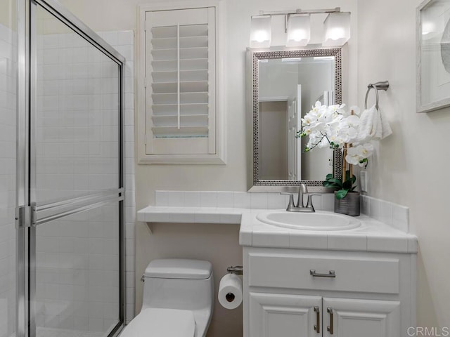 full bathroom with a stall shower, vanity, and toilet