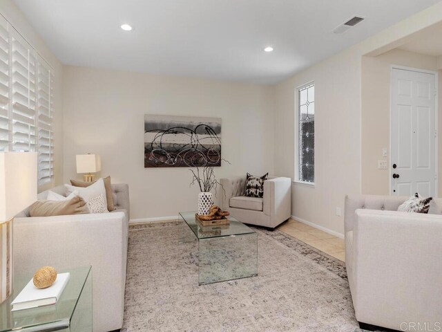 tiled living room featuring baseboards, visible vents, and recessed lighting