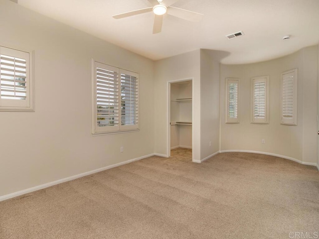 unfurnished bedroom with carpet floors, visible vents, baseboards, and multiple windows