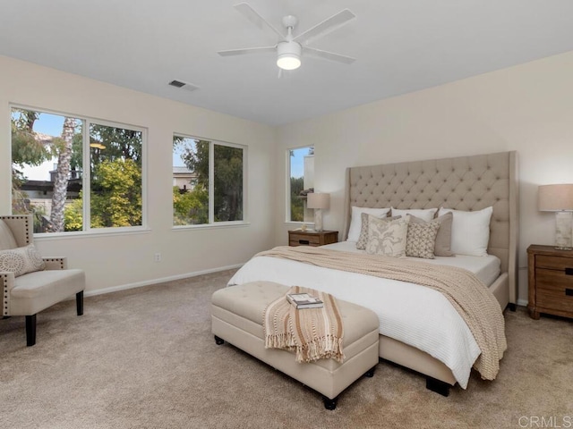 carpeted bedroom with baseboards, visible vents, and a ceiling fan