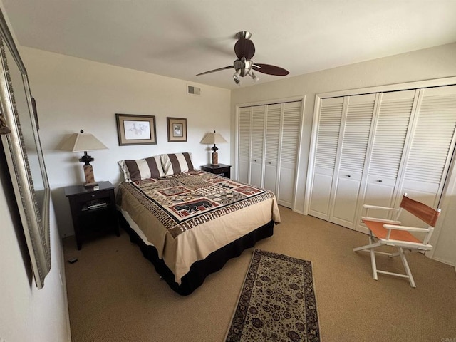 bedroom featuring visible vents, multiple closets, a ceiling fan, and carpet flooring