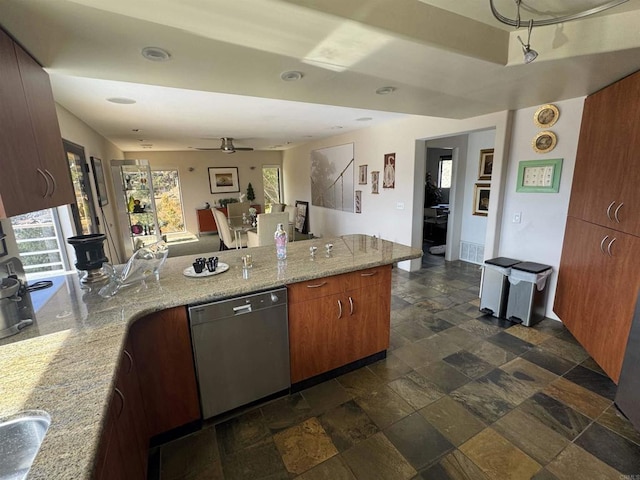 kitchen featuring stone tile flooring, a ceiling fan, a peninsula, stainless steel dishwasher, and light stone counters