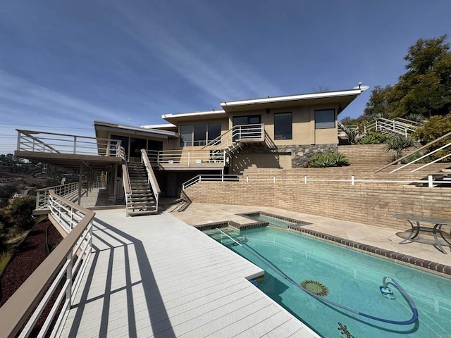 view of pool featuring a wooden deck, stairway, a patio area, a jacuzzi, and a fenced in pool