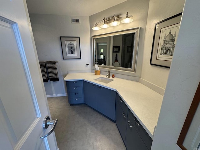 bathroom featuring a textured wall, vanity, and visible vents