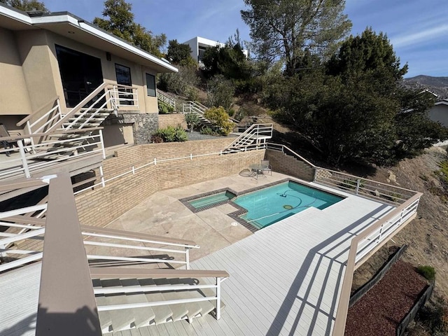 view of pool featuring stairs, a patio, and a pool with connected hot tub