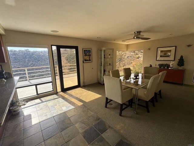 dining area with stone finish flooring and a ceiling fan