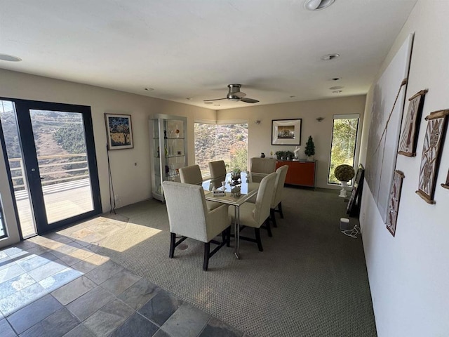 dining space featuring stone finish floor and a ceiling fan