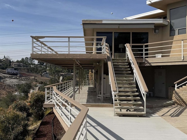 entrance to property featuring a deck and stucco siding