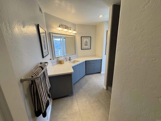 bathroom featuring vanity and a textured wall