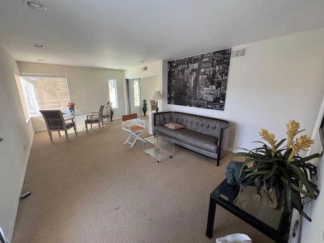 living area with carpet floors, baseboards, and visible vents