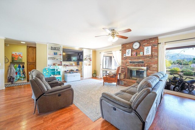 16233 Oakley Rd, Ramona, CA 92065 - living room featuring ceiling fan, a fireplace, wood finished floors, and crown molding