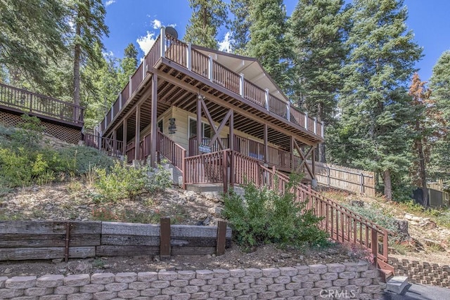 view of front of home featuring fence, stairway, and a deck