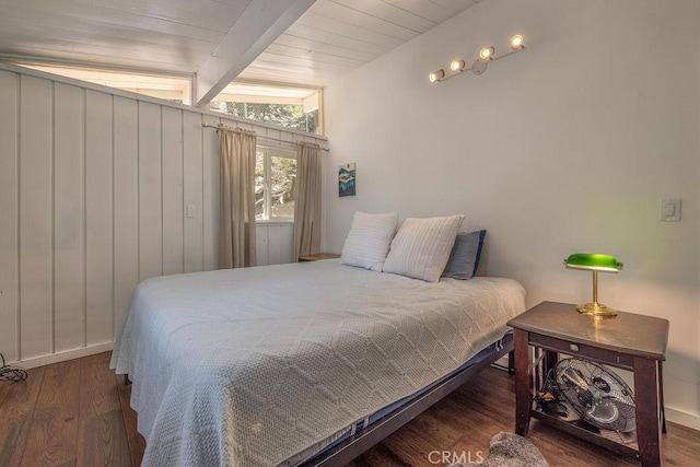 bedroom featuring beamed ceiling, wood finished floors, and wood ceiling