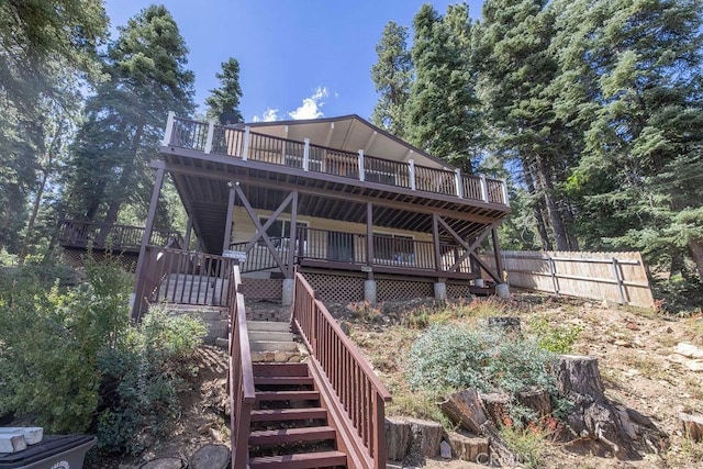 rear view of property with stairs, fence, and a wooden deck