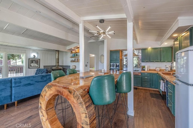 kitchen featuring dark wood-style floors, freestanding refrigerator, a sink, and green cabinets