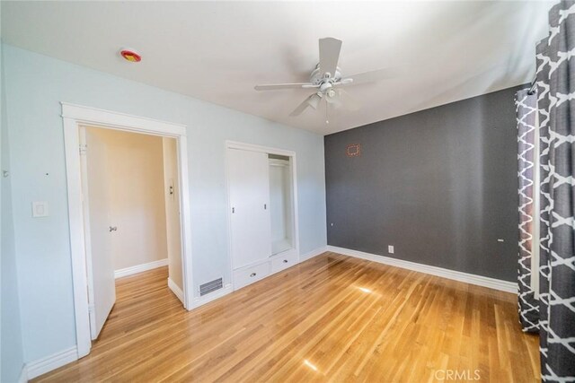 unfurnished bedroom with visible vents, baseboards, ceiling fan, light wood-style floors, and a closet