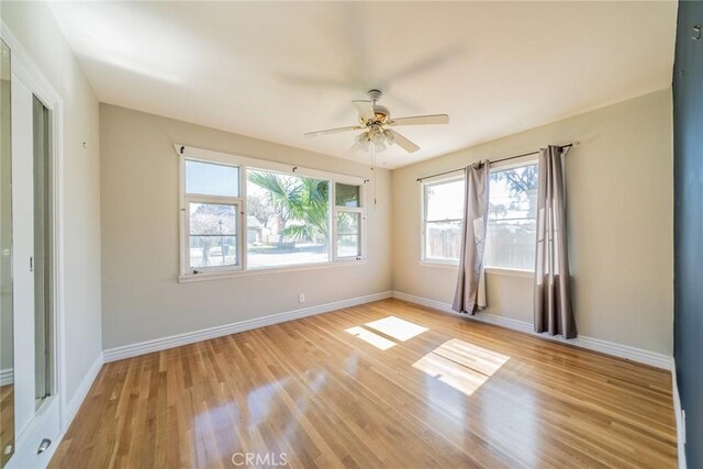 unfurnished room featuring ceiling fan, light wood-type flooring, and baseboards