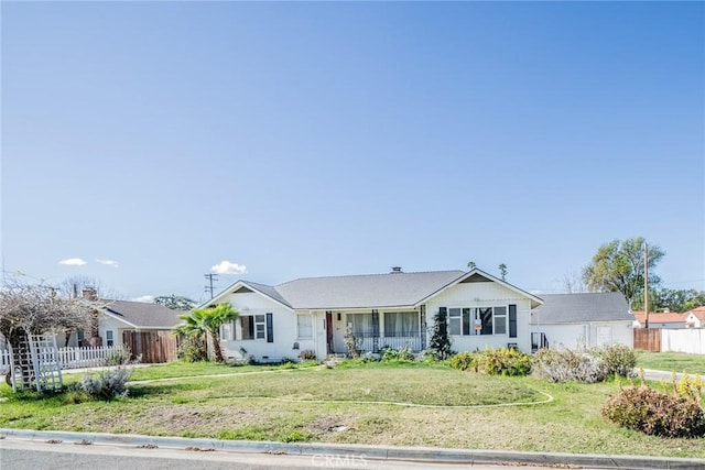 ranch-style home with a garage, fence, and a front lawn