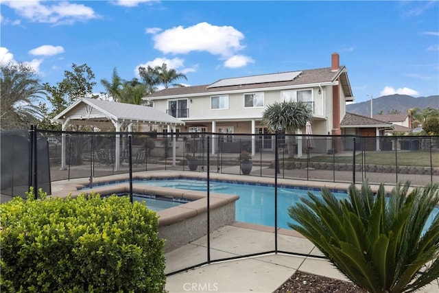 view of pool with a mountain view, an in ground hot tub, fence, a gazebo, and a fenced in pool