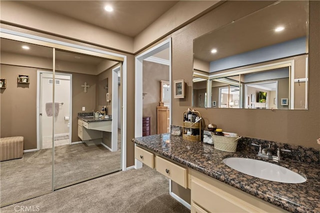 bathroom with baseboards, radiator heating unit, vanity, and recessed lighting