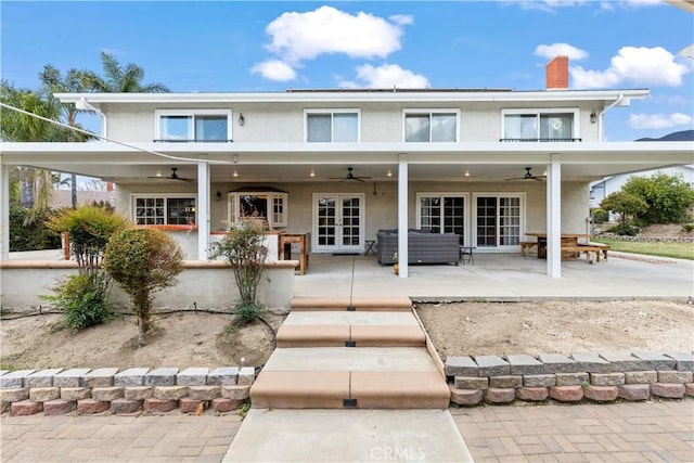 rear view of property with a patio, french doors, a ceiling fan, and stucco siding