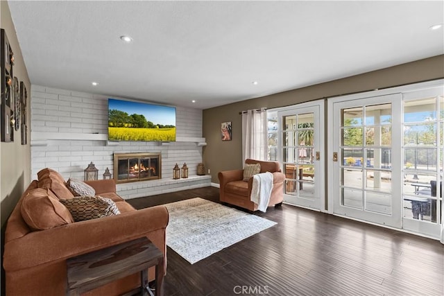 living area with dark wood-style floors, recessed lighting, and a fireplace